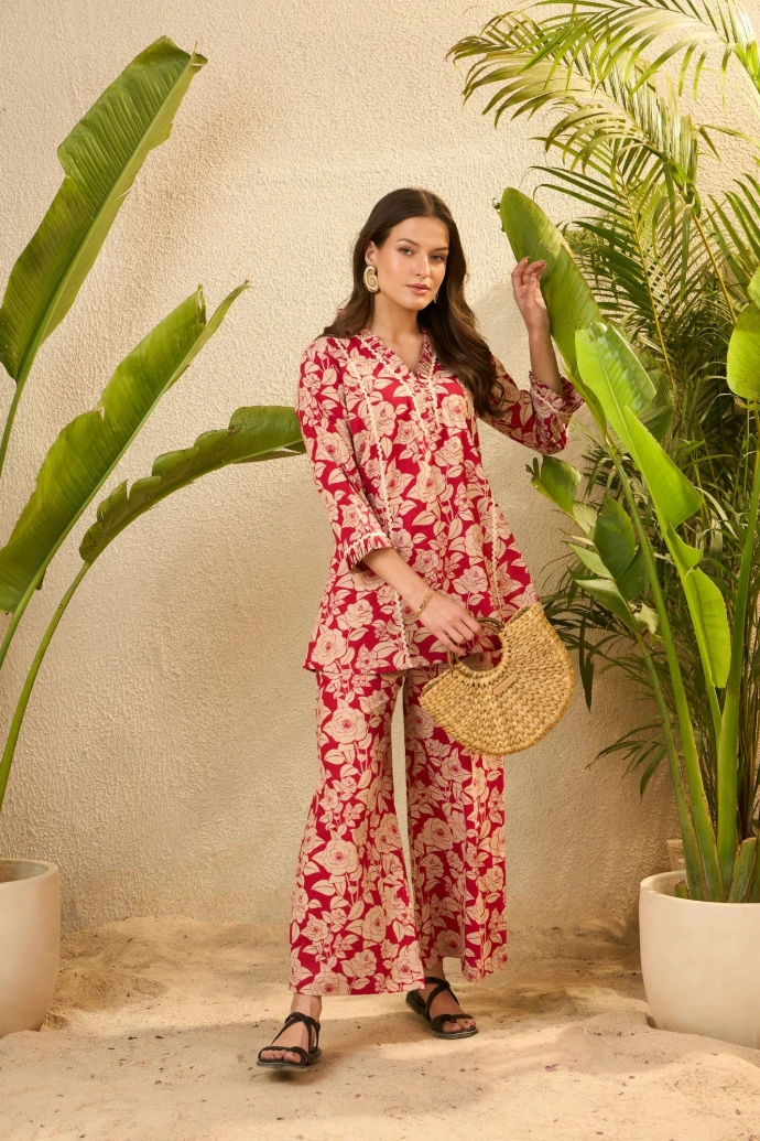Woman in floral outfit holding straw bag near plants